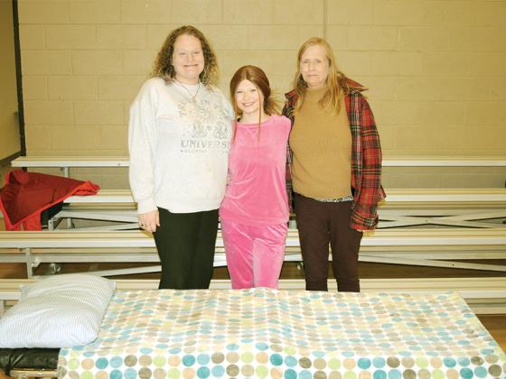 Volunteers prepare to receive guests at the Gilmer County Warming Center. From left are, Madeline Natzke, Mia Johnson and Ingrid Natzke.