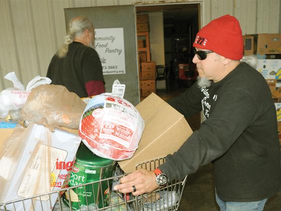 Dave Krier moves a cart of food including a delicious Thanksgiving turkey at the Gilmer Community Food Pantry on Wednesday, Nov. 19.