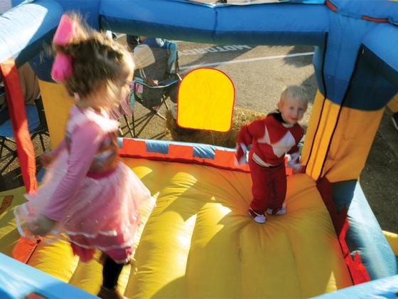 Emalynn Chastain, left, dressed as Princess Barbie and Walker Cruce dressed as a Power Ranger, right, frolic in a bouncy house at the Ellijay First Baptist Church’s Fall Festival, Oct. 31.