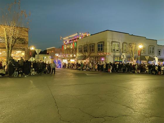 Crowds of festivalgoers line the streets in anticipation of the parade just before it starts.
