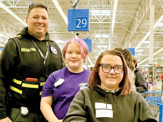 Homeland Security Coordinator Keven Stanfield, left, Willow Allen of Mountain View Elementary school and her mother, right, visit Walmart together for Shop with a Hero Saturday, Dec. 13.