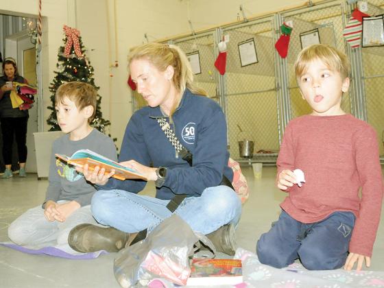 A family visits the Gilmer County Animal Shelter to read to dogs awaiting adoption Monday, Dec. 22. Shown from left are Henry Hoover, Leigh Hoover and Howell Hoover.