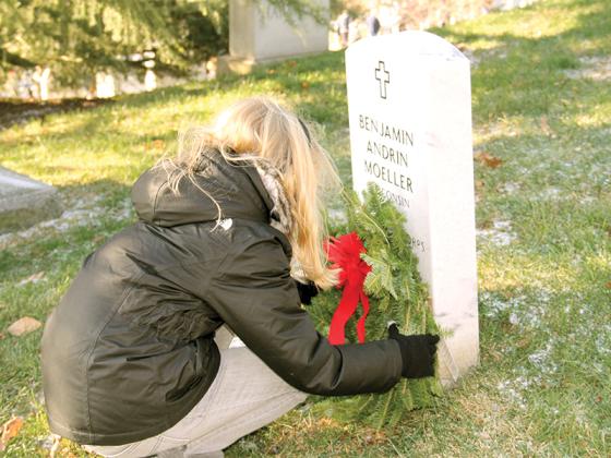 An unidentified volunteer places a wreath at the grave of Major Benjamin Andrin Moeller, a U.S. Marine in World War I. (Wreaths Across America photo)