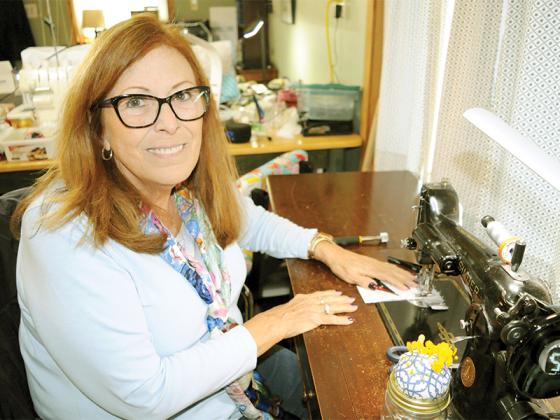 Terri Olsen sits down at her nearly 100-year-old sewing machine, a key tool for making beautiful quilts.
