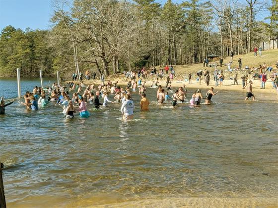 New Year celebrants run out of the water after plunging into Fort Mountain Lake’s chilly waters.