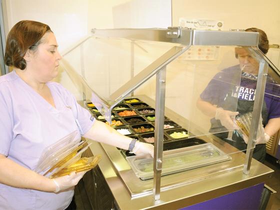 Gilmer High School Assistant Manager Jackie Chadwick, left, and Manager Karen Pinson, right, prepare a salad bar including locally grown foods.