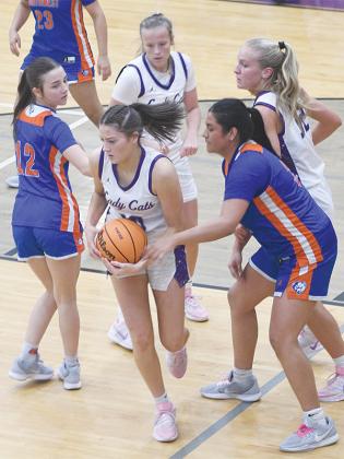 Senior Chelsey Griggs snags a rebound while Mak Taylor and Paula Robertson help defend the post.