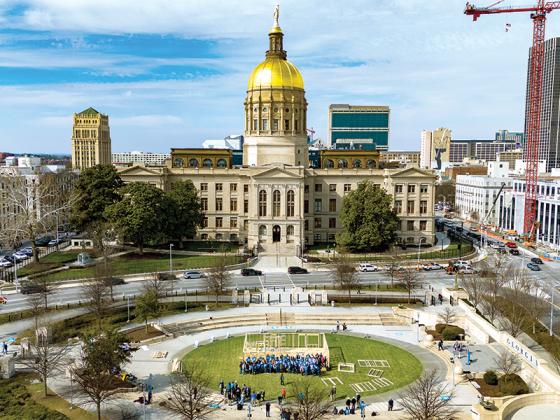 A drone shot shows the Georgia Capitol Building and the house Habitat for Humanity volunteers built.