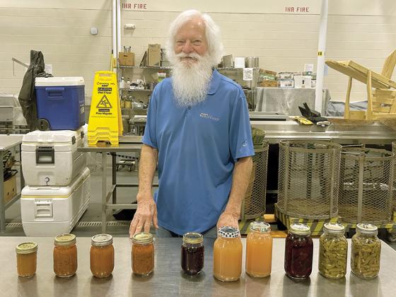 Cannery Supervisor Larry Young displays a set of canned foods produced at the Gilmer County Cannery.