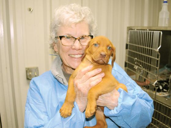 Denise Burns shares a happy moment with a puppy at the Gilmer County Animal Shelter Thursday, March 19.