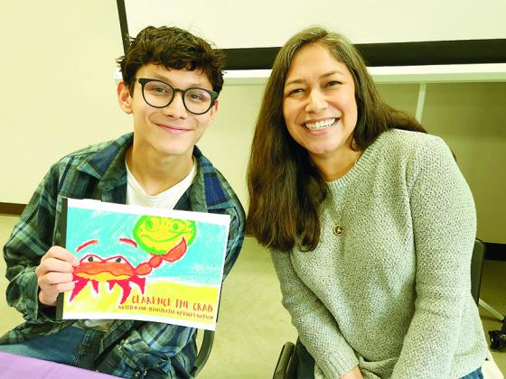 Local author Luke Watson, left, and his mom Tiffany Watson, right, celebrate his book at the Local Authors Forum.