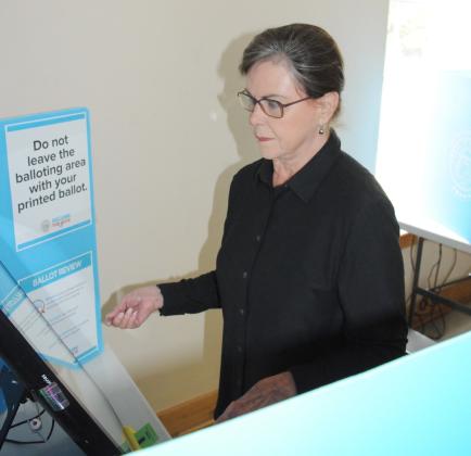 Gilmer resident Leigh Garrett votes in the primary run-off Tuesday, June 16. Below, Tommy Jacobs and James Garrett take their turns at the poll.