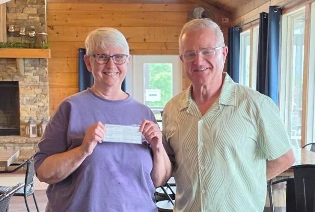 Friends of Gilmer Animal Shelter President Sylvia Harris, left, receives $1,000 from Gilmer Pickleball Club President Eddie McDonald, right.