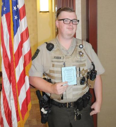 Deputy First Class Caleb Peardon holds a copy of “A Policeman’s Prayer” by Mabel Degeneste during his shift at the Gilmer County Courthouse.