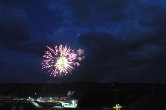 A purple firework shines in the sky at dusk on America's 250th July Fourth in Ellijay, Georgia.