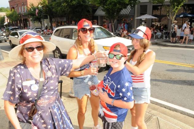 Daughters of the American Revolution member Terri Olsen hands out candy to Independence Day attendees in Ellijay.