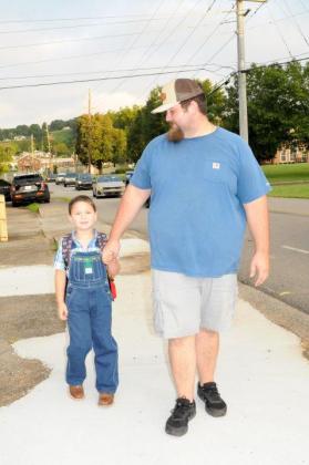 Slade Dishman, left, and his father Colton Dishman, right, walk together to his first day of school at Ellijay Elementary School on Monday, Aug. 3.