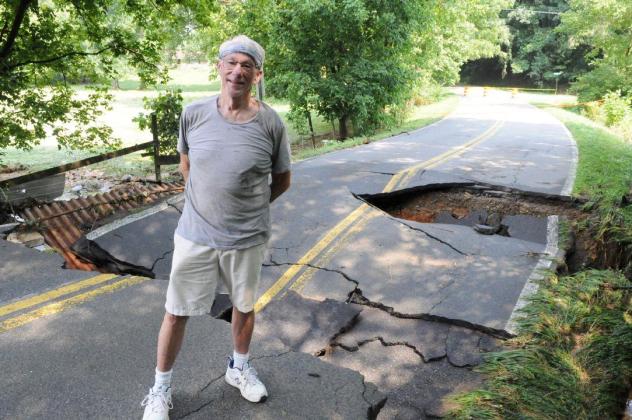 Gilmer resident Austin Sallade examines major washout damage to Gates Chapel Road from the storm on Tuesday, July 28.