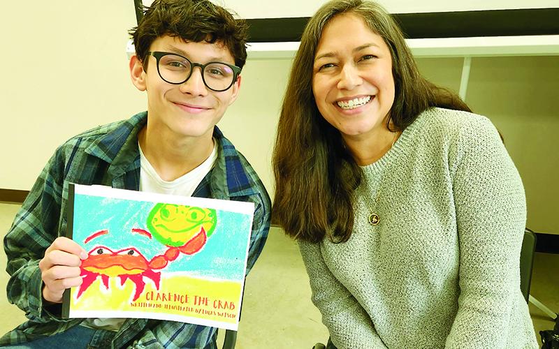 Local author Luke Watson, left, and his mom Tiffany Watson, right, celebrate his book at the Local Authors Forum.