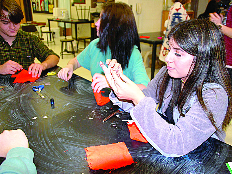 Bianca Breading practices hand sewing in basic sewing class.