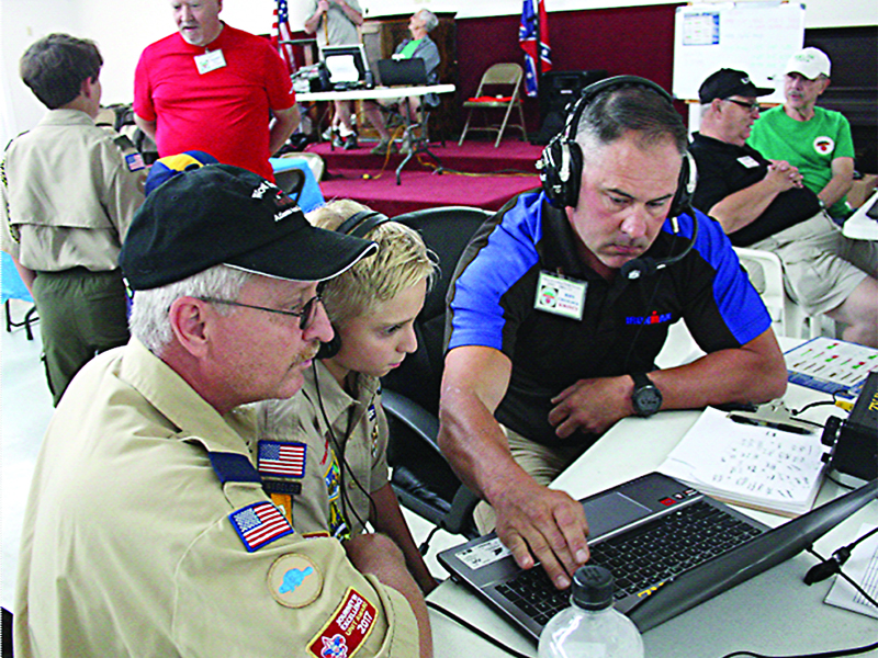 Ron Cheslock, of the Ellijay Amateur Radio Society (EARS), right, shows Tommy Parker, left, and son, Tommy Parker Jr., both of Cub Scout Pack 404, some of the equipment used by local ham radio operators during an EARS Field Day earlier this year.