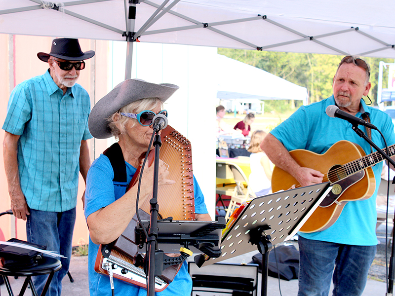 After helping them set up at the Dancing Goat Folkfest, Larry Cockerham (top right) watches as ‘Jerry Lynne & Patrick’ belt out their rendition of Ring of Fire.