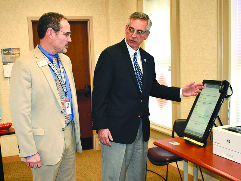 Georgia Secretary of State Brad Raffensperger demonstrates how to use the new voting machines to Gilmer County Probate Judge and Election Superintendent Scott Chastain.