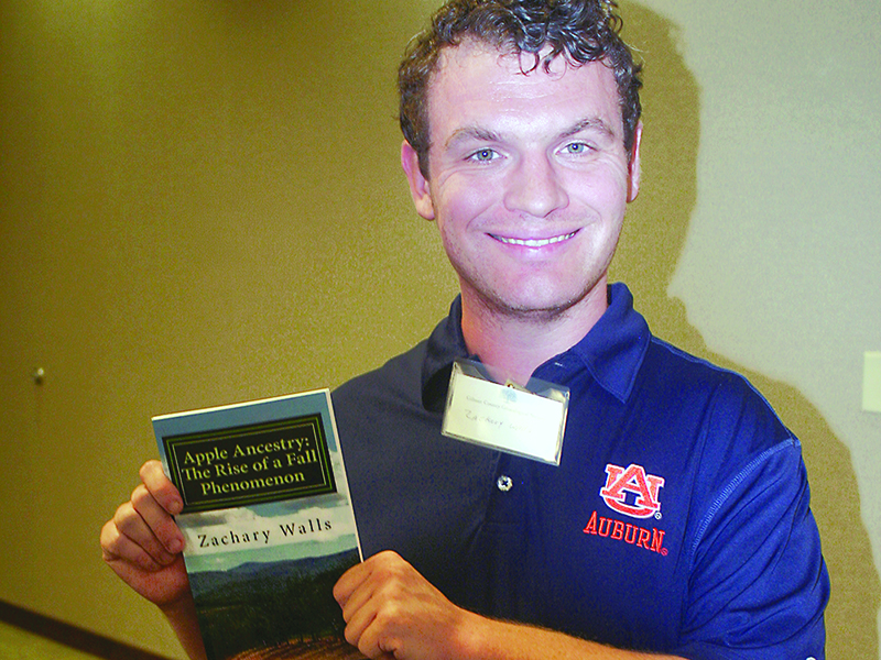 Zachary Walls holds a copy of his first book, Apple Ancestry: The Rise of a Fall Phenomenon.