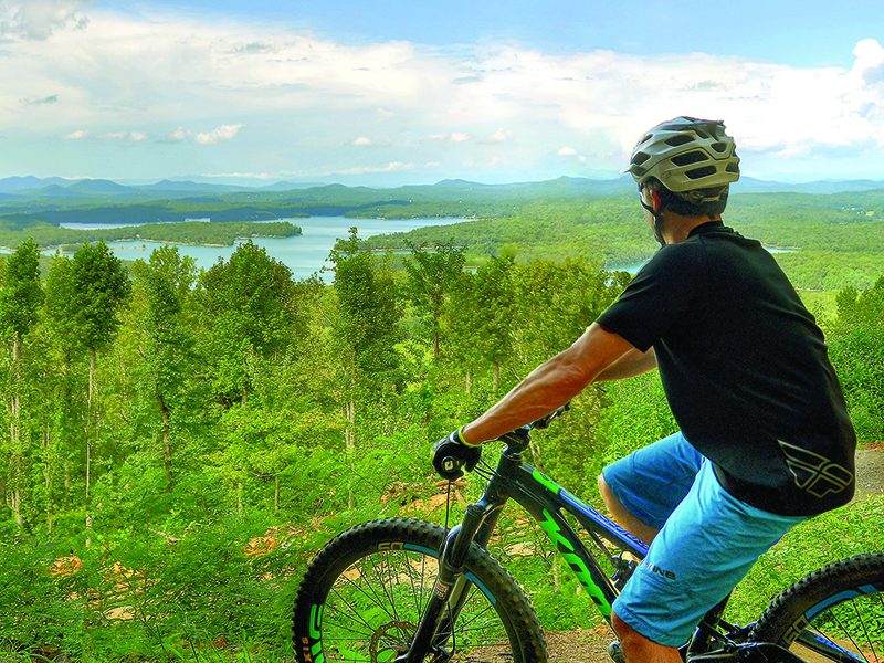 Mountain biker AJ Petrillo takes in a panoramic view of Lake Blue Ridge from one of the Aska trails. 