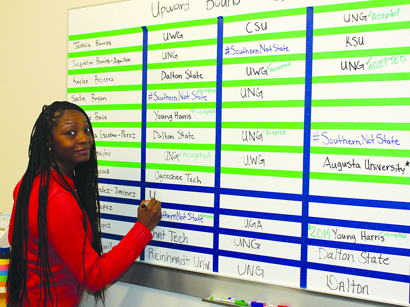 Latrice Richardson, coordinator of the federally-funded Upward Bound program at Gilmer High School, keeps track of students’ college campus visits on one of two boards. 