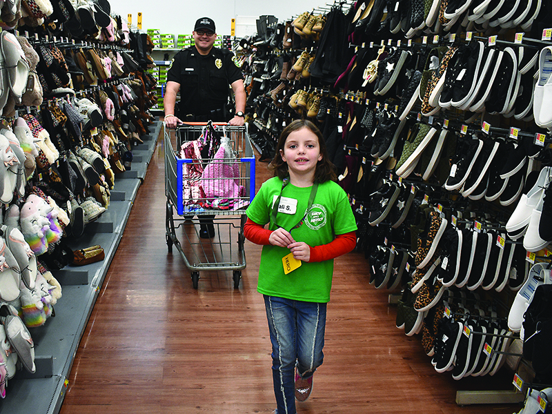 Cali S. and Ellijay Police officer Ryan Lowery cover the aisles at the East Ellijay Walmart during the county’s first Shop With a Hero event.