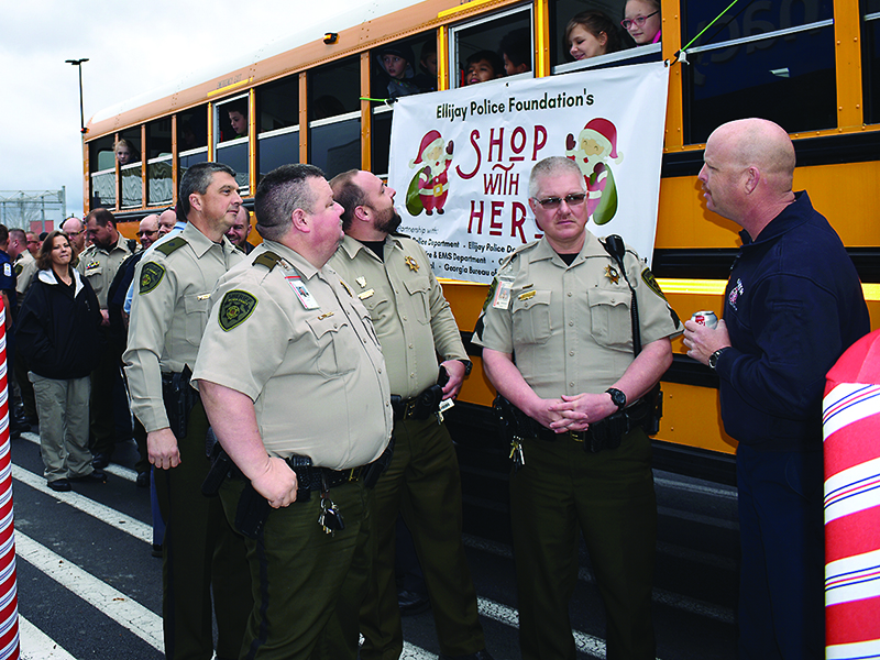 From left, Maj. Adam Smith, Capt. Brian Crump, Lt. Josh Chancey and Sgt. Greg Dotson, of the Gilmer Sheriff’s Office, and Brian Scudder, of Gilmer Fire and Rescue, wait in front of the East Ellijay Walmart to be paired with children participating in the Shop With a Hero program.