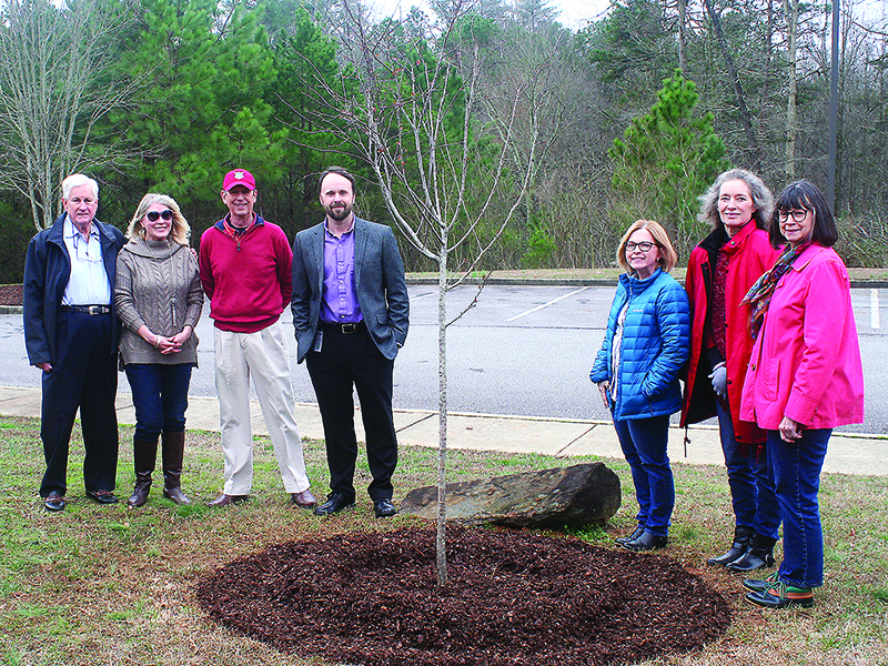 Garden Club of Ellijay members Scarlet Howard, Bonnie Waldron and Joanne Waddey, fifth from left to right, and Heath Lee, Gilmer County Library manager, fourth from left,  are joined by Jack Nunn, Lou Anne Nunn and George Bunch III, all family of founding garden club member Annetta Bunch, for a special Arbor Day tree planting in front of the library. 