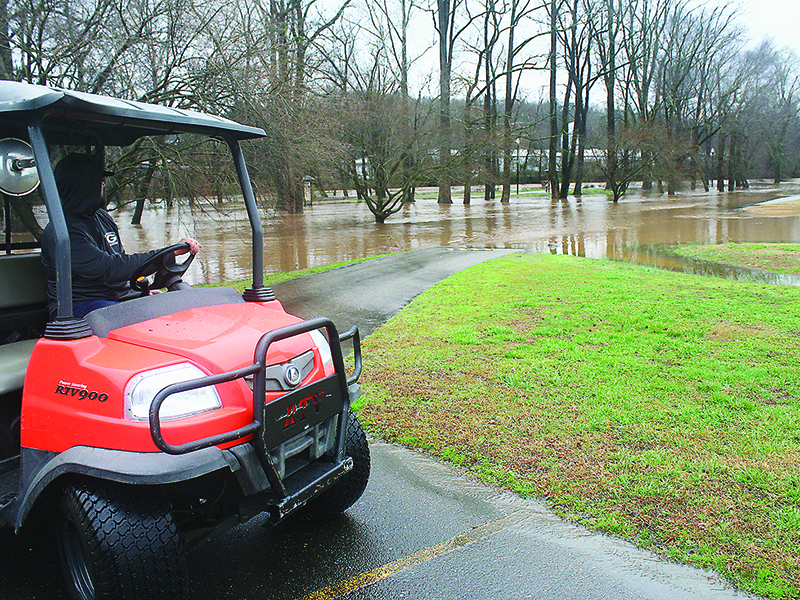Tatum Chadwick, of Gilmer Parks and Recreation, is about to drive through standing floodwater that swallowed the walking trail at River Park last Thursday morning. The park, along with local schools and several county government offices, closed early due to the hazardous weather conditions. (Michael Andrews/ Mountain Life Editor)