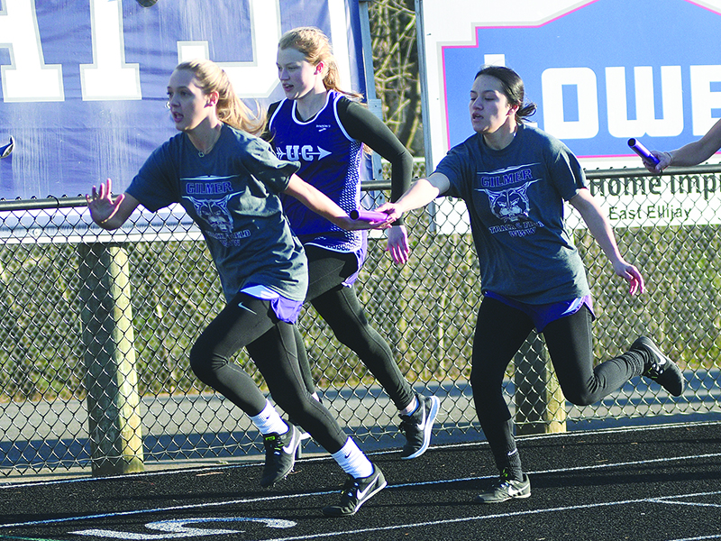 Lady Cat Rachel Bennett takes the baton from teammate Karla Orduna during the 4x100 relay.