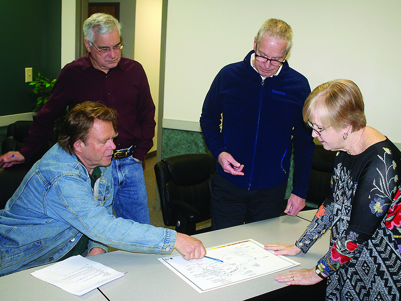 From left, members of the Harrison Park Advisory Board and Friends of Harrison Park Rick Lucas, Mike Lancaster, Al Fuller and Linda Lancaster look over a concept plan that shows how amenities could be positioned at the downtown Ellijay walking park within the next 10 years.