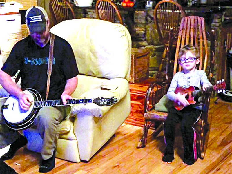 Barry Abernathy, a banjo picker with a congenital birth defect in his left hand, plays as his adopted son Tyler, with the same defect, strums along.