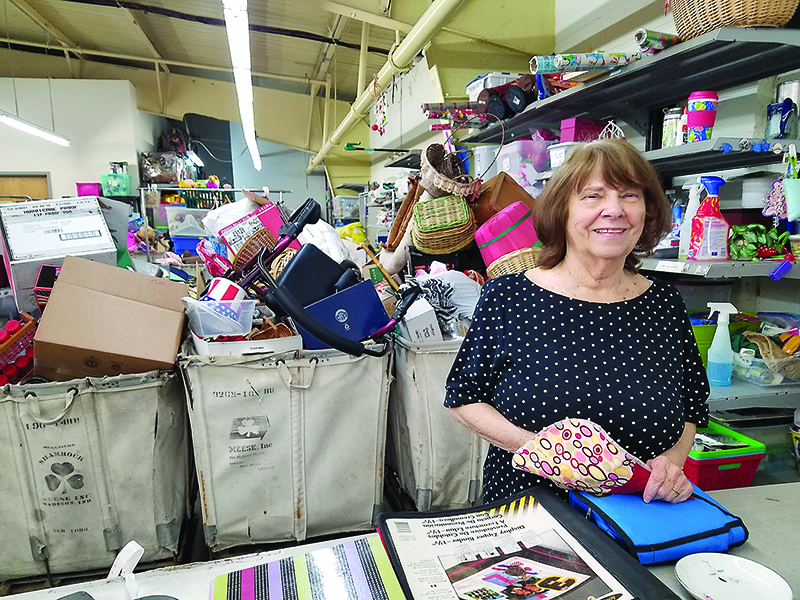 Above, Bonnie Green, a volunteer at Faith, Hope and Charity Recycle Store, sorts through carts of donated items, while, below, volunteer Stacy Grahm cleans and organizes shelves in preparation for the thrift store’s planned reopening. 