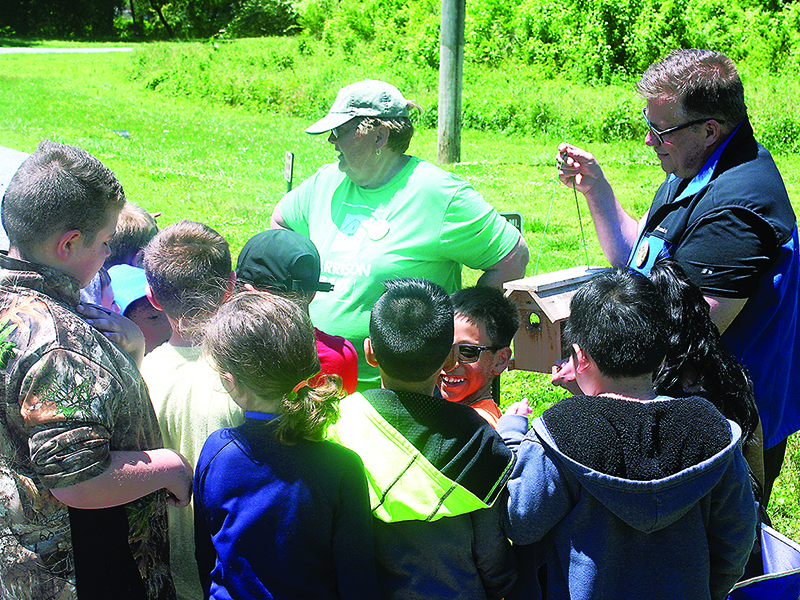 Pam Johnson and Todd Adamson, of Friends of Harrison Park, take an elementary school class on a tour of the park’s bluebird trail during an educational visit last year. 