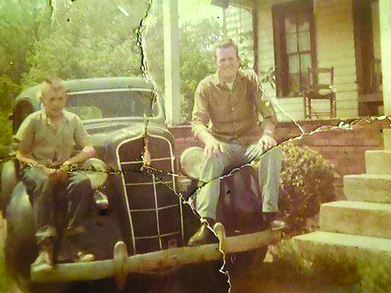 He and younger brother Ronnie sit on an antique car.