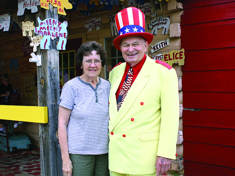 Oscar and Edna Poole are pictured in front of their East Ellijay family business Poole’s BBQ. Oscar Poole sports the yellow suit and red, white and blue accessories that brought him attention in the worlds of food and politics.
