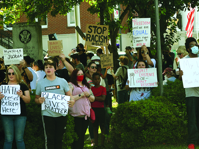 A crowd of people hold up signs during a rally on the square in downtown Ellijay on June 4. Organizers said  the wanted to give people a place to voice their frustrations and concerns over racism.