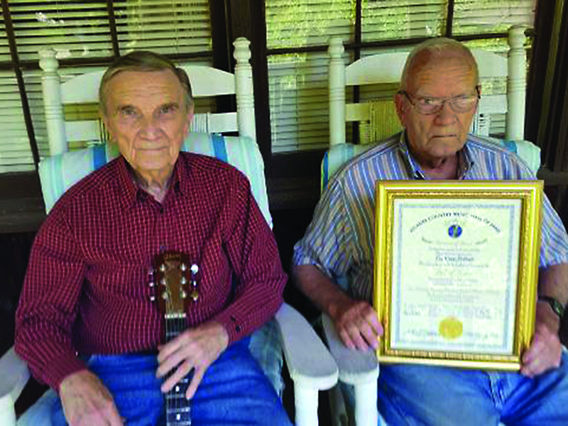 Larry and Vic Davis show a plaque that recognizes their induction into the Atlanta Country Music Hall of Fame.