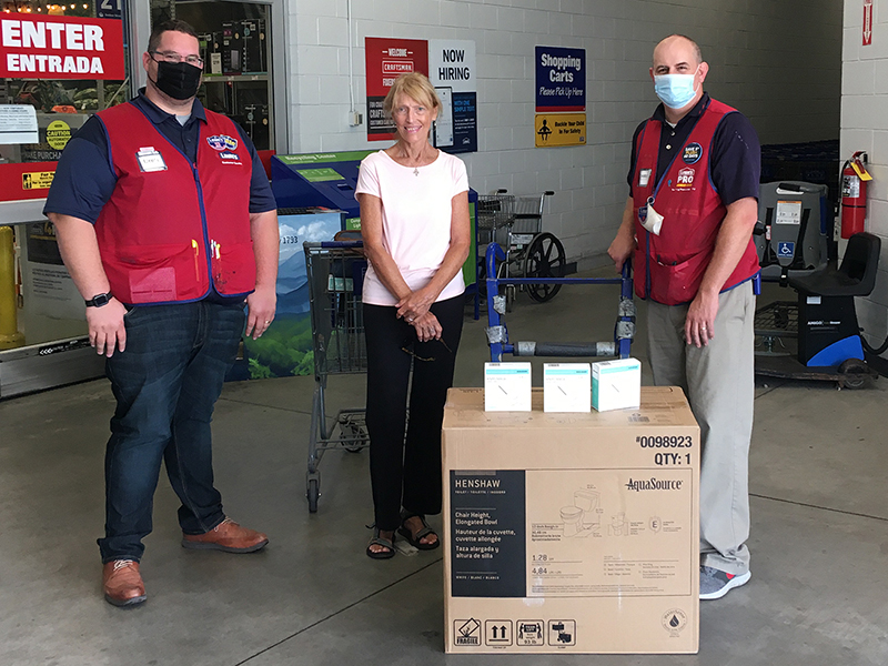 Karen Vitelli, a volunteer at the Gilmer Historical Society’s Tabor House Museum, center, is pictured accepting a donation of two new toilets and boxes of face masks from East Ellijay Lowe’s store manager Brett Thompson, left, and assistant manager Chris Green, right.