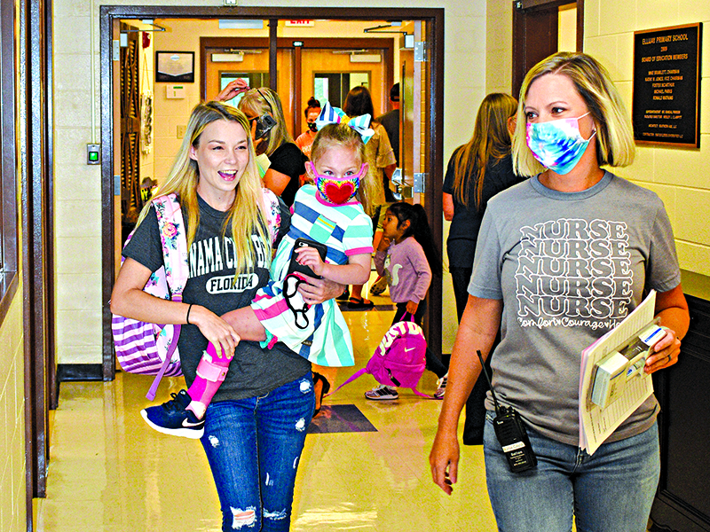 Pre-K student Bella Banks and mom Crystal venture to class on the first day of school with assistant from school nurse Cayla West at Clear Creek Elementary school.