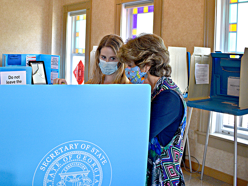 Kathy Tankersley assists Leah Davis during early voting at the Gilmer County Courthouse for the Aug. 11, primary runoff.