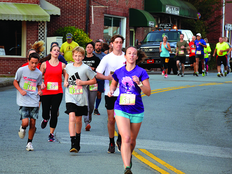 Above, below, Apple Festival 5K participants head up North Main Street during last year’s race.