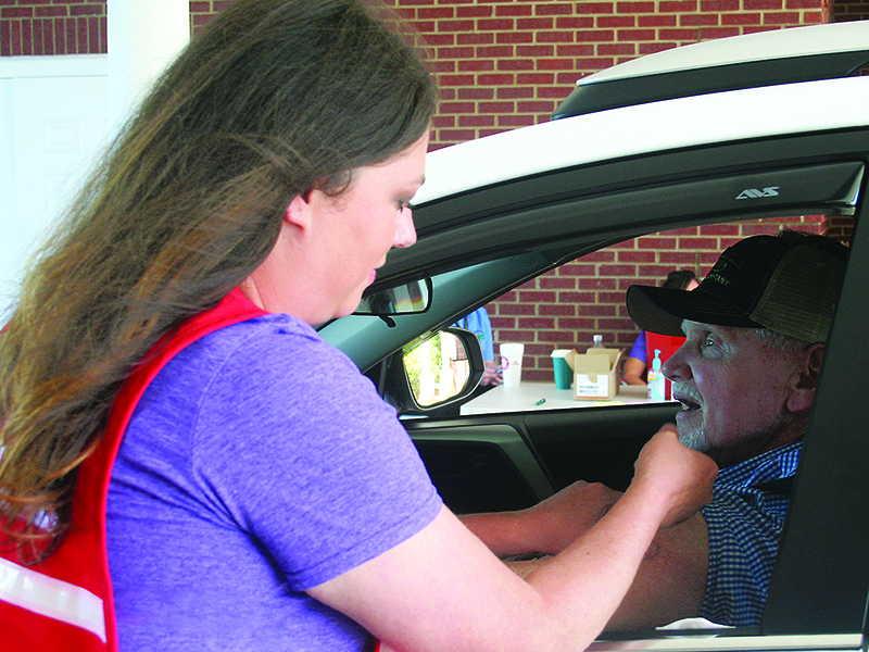 Gilmer Health Department nurse Jennifer Vick vaccinates a patient during one of the health department’s past drive-thru flu shot clinics.
