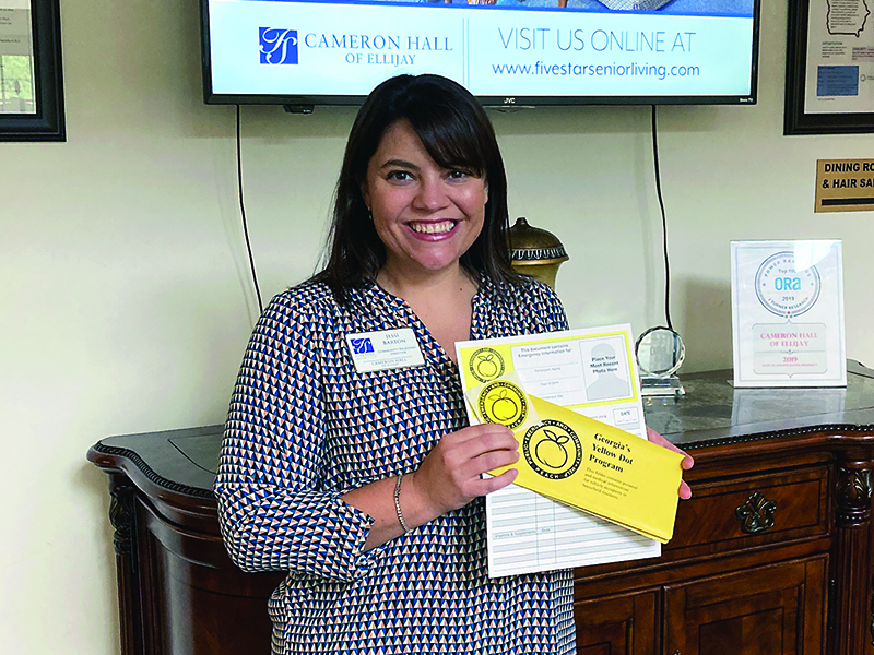 Jessi Barton, of Cameron Hall of Ellijay, holds one of the 1,500 Georgia Yellow Dot medical information packets now available to Gilmer County residents.