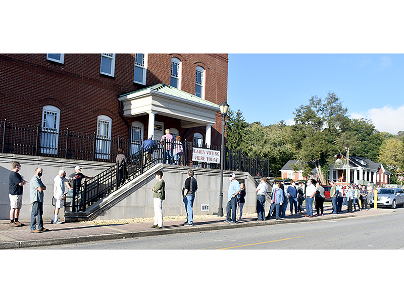 Gilmer County voters lined up around the Gilmer County Courthouse Tuesday morning patiently waiting to cast their ballot on the first day of early voting.